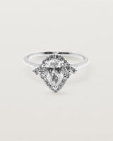 A pear cut diamond, framed by a halo of white diamonds crafted in white gold.