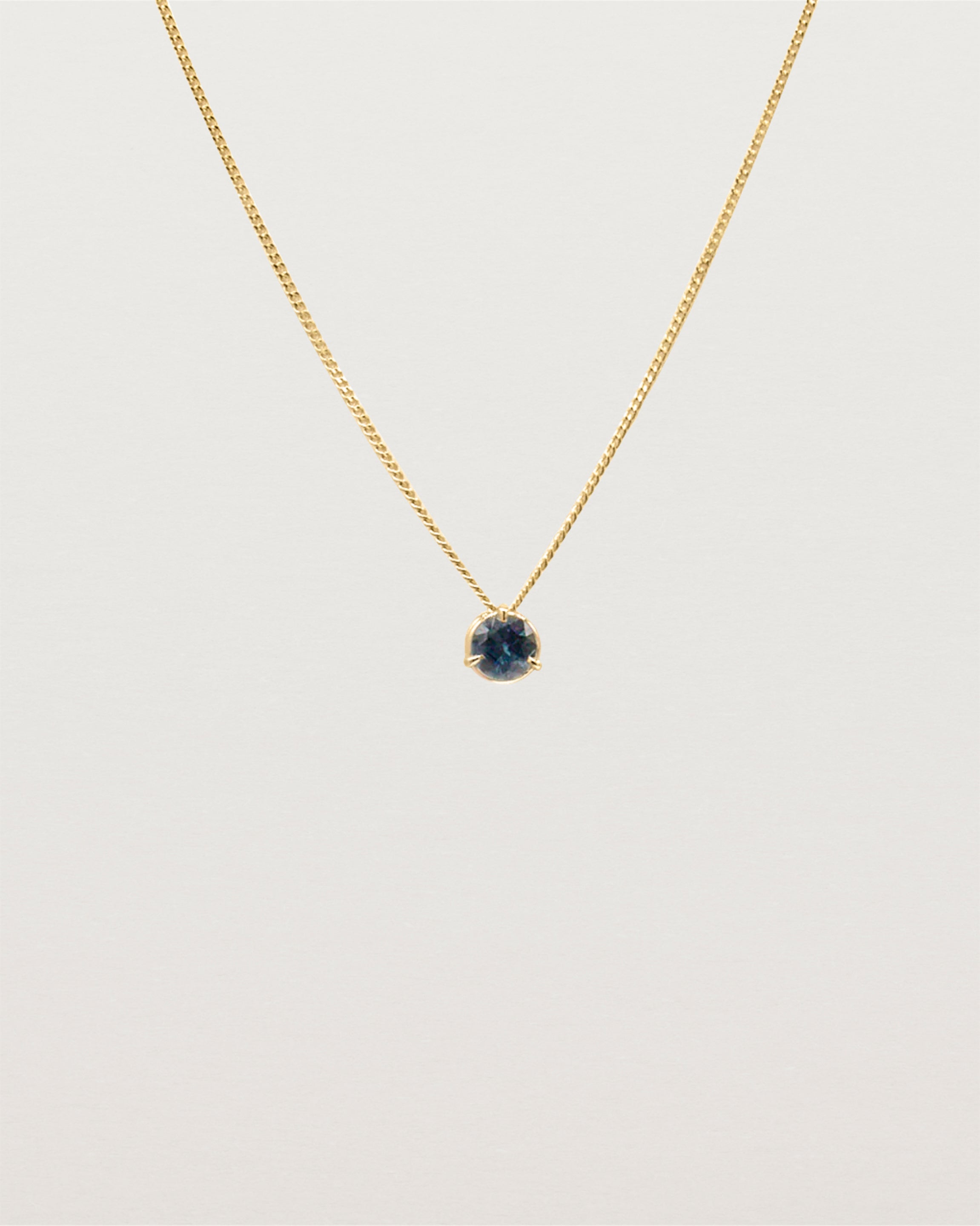 A 3mm blue sapphire is set simply on a fine chain. 