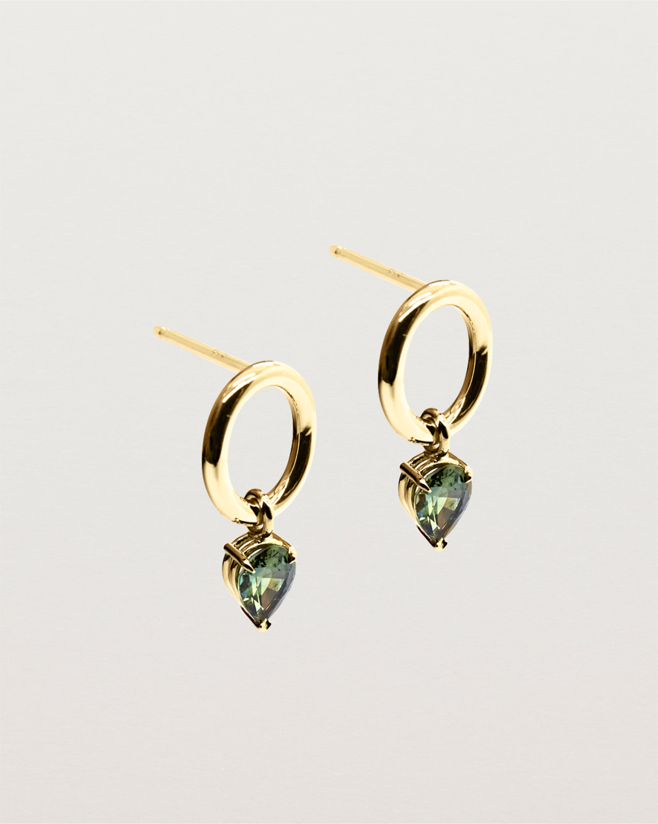 Delicately hanging, a three claw basket setting holding a stunning pair of Australian green sapphires.