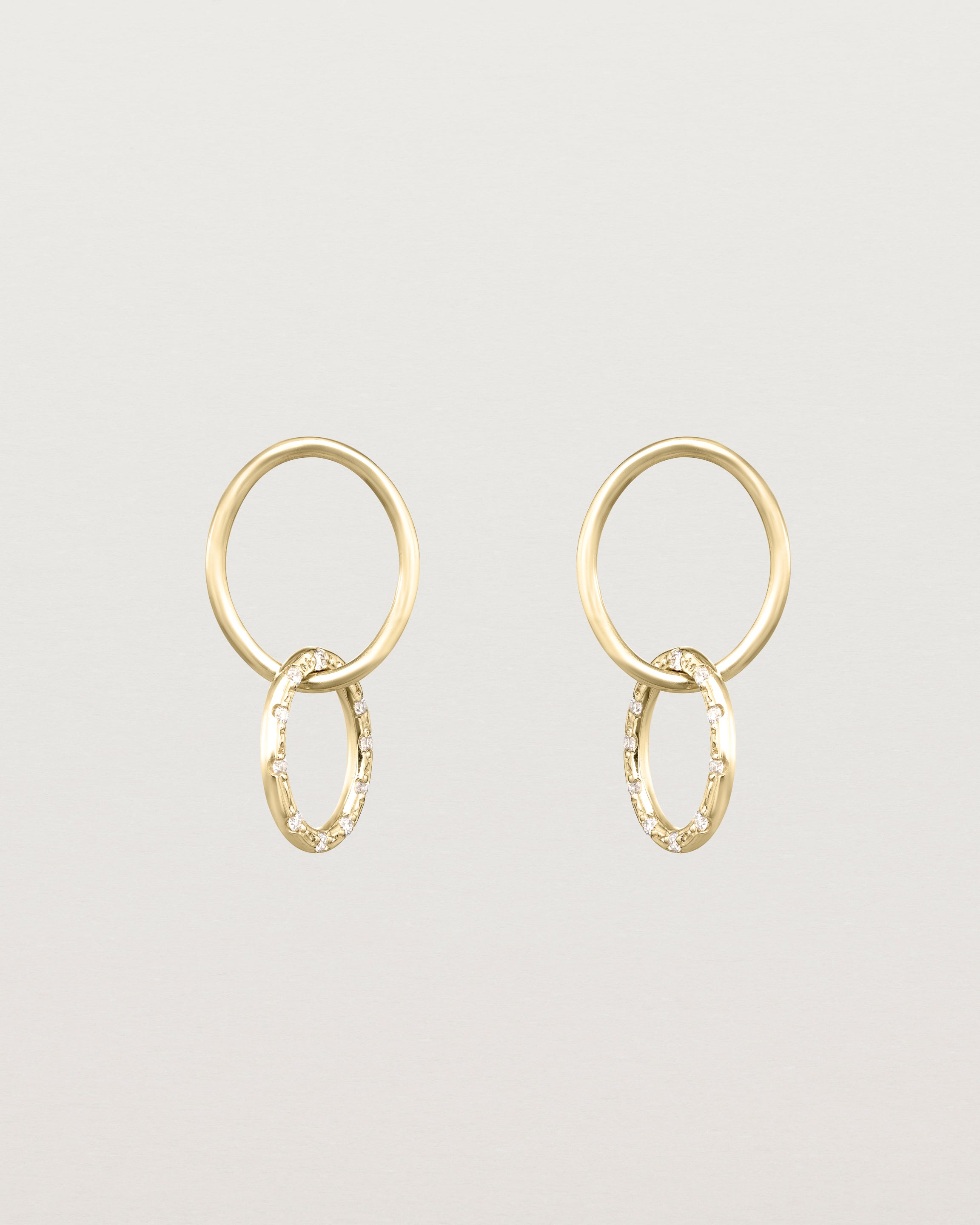 Front view of the Cascade Loop Through Oval Studs | Diamonds in yellow gold.