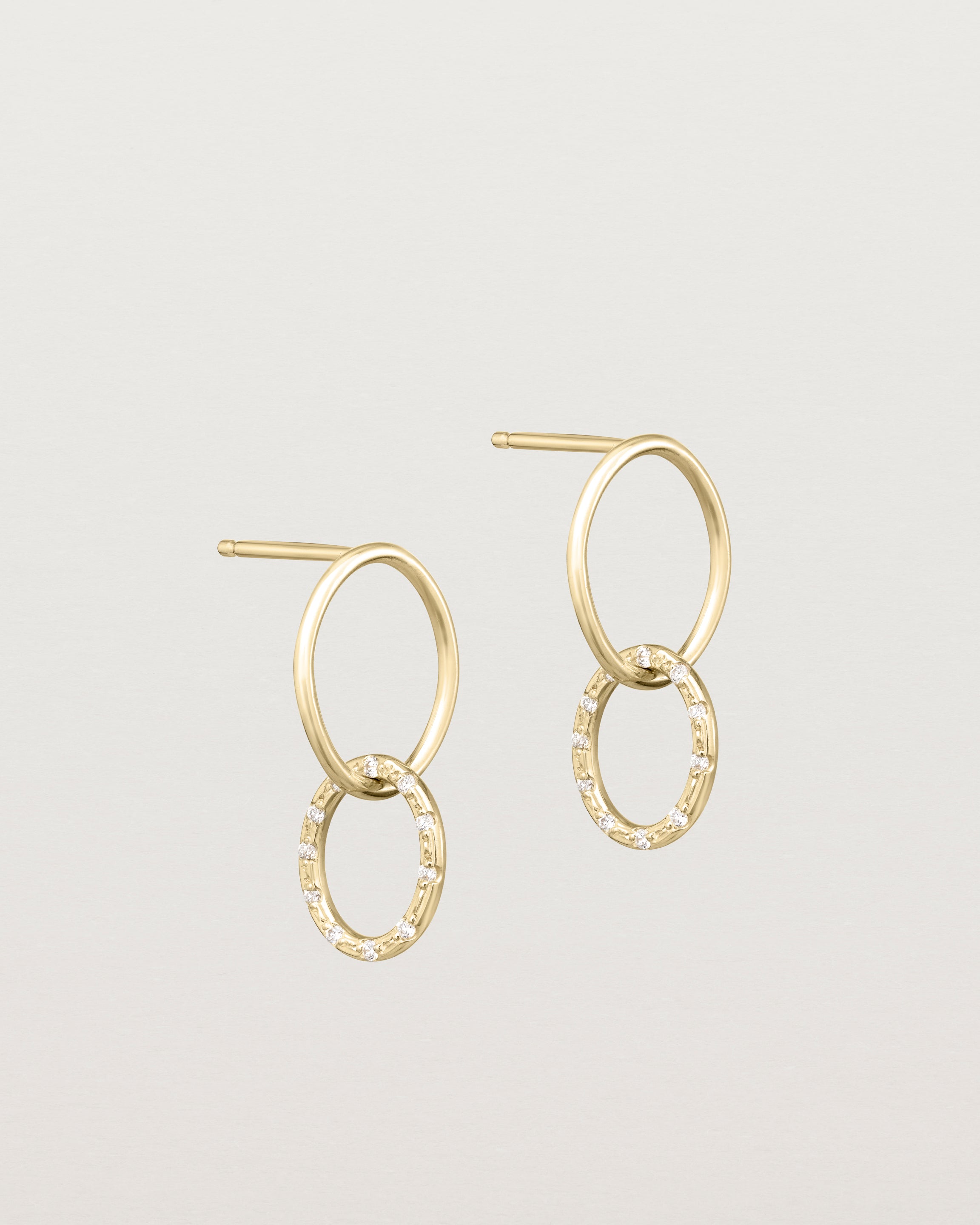Angled view of the Cascade Loop Through Oval Studs | Diamonds in yellow gold.