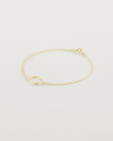 A white gold chain bracelet featuring a gold circle set with small white diamonds