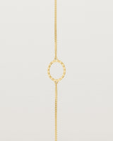 A white gold chain bracelet featuring a gold circle set with small white diamonds