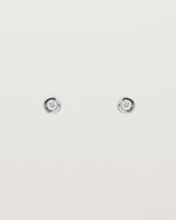 A small circular white gold stud featuring a white diamond