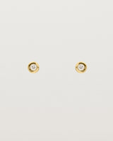 A small white circular yellow gold stud featuring a white diamond