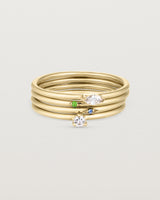 A set of four yellow gold rings, featuring white diamonds and blue sapphire and an emerald.