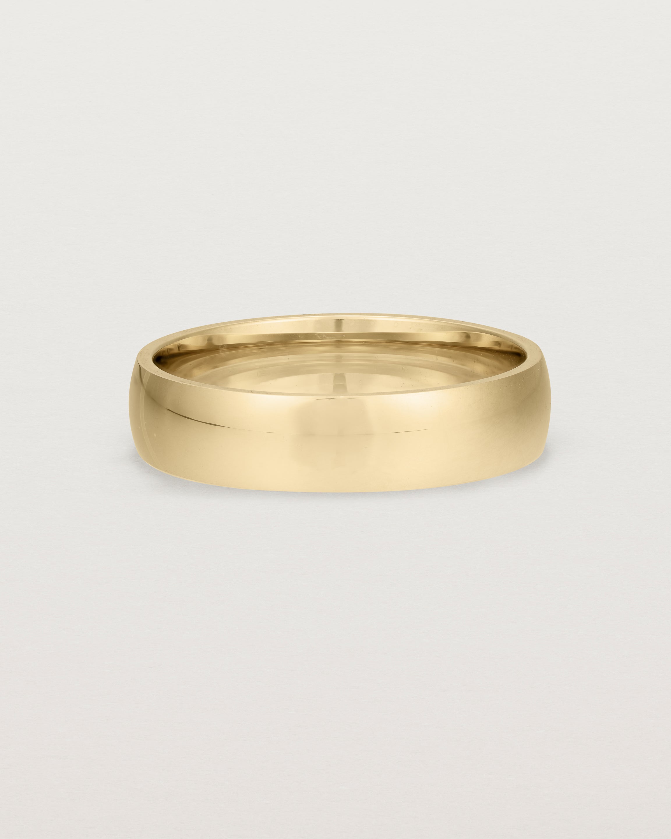 The front view of a 5mm wide heavy wedding ring in yellow gold. 