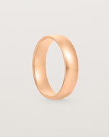 The front view of a 5mm wide heavy wedding ring in rose gold. 