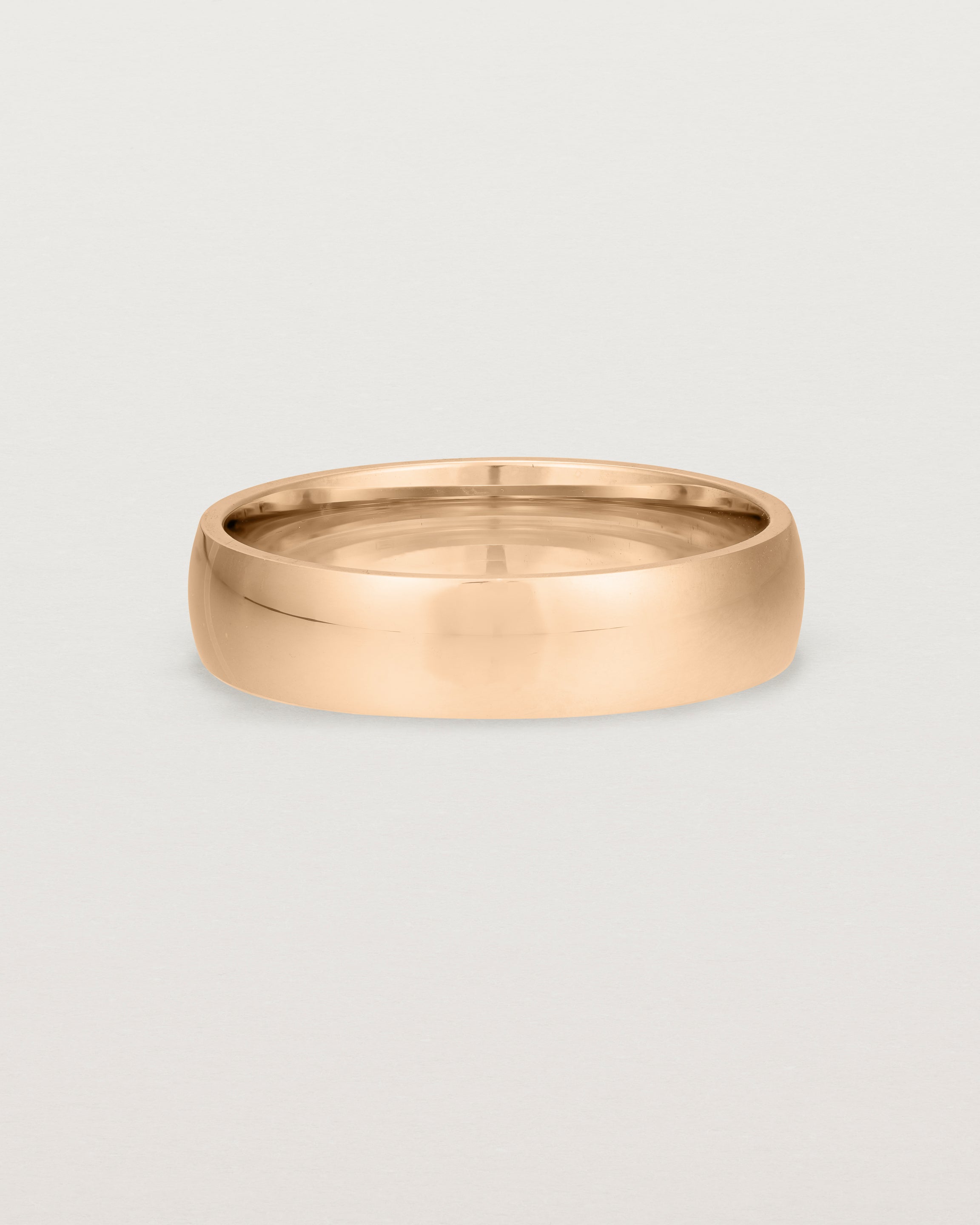 The front view of a 5mm wide heavy wedding ring in rose gold. 