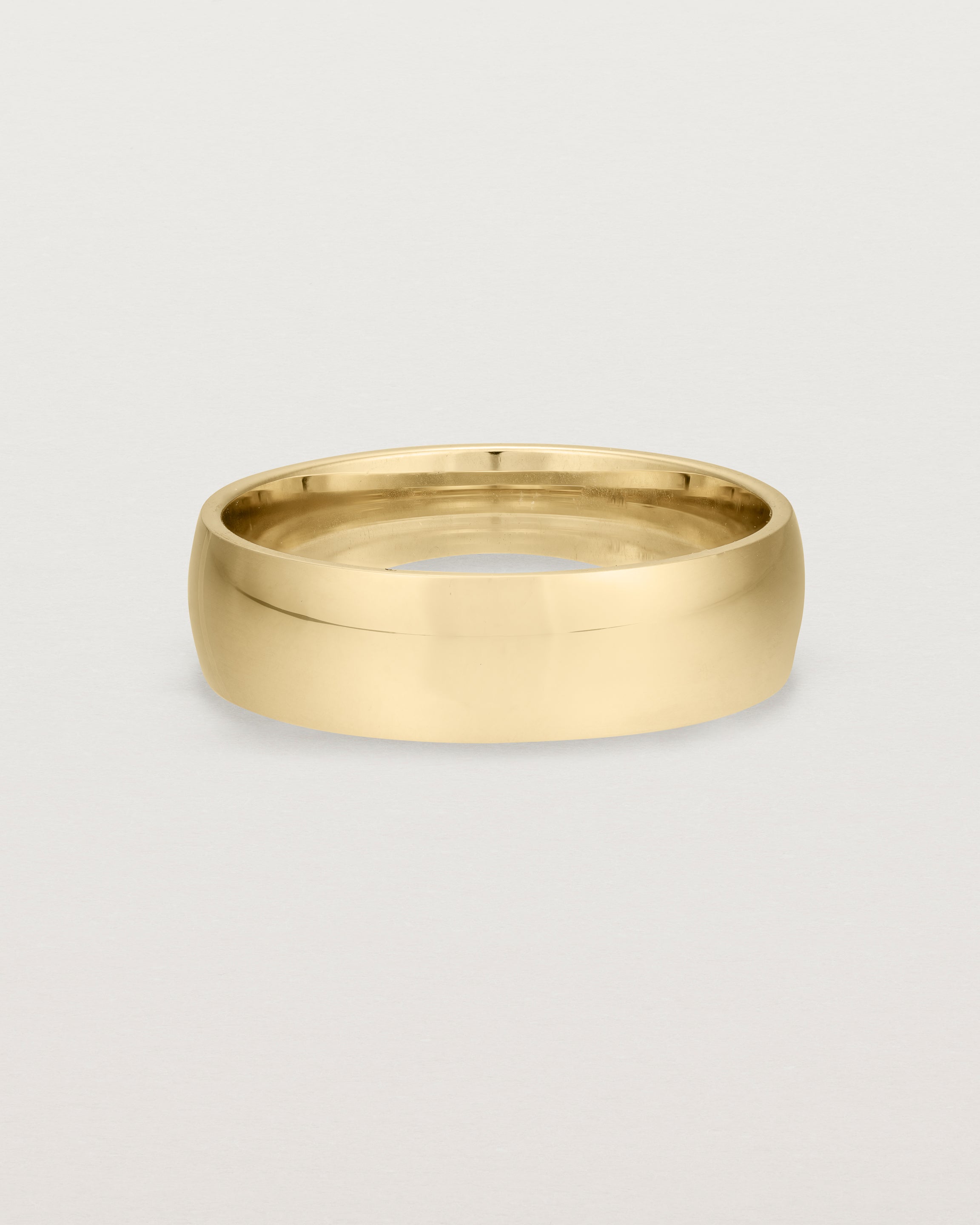 The front view of a heavy 6mm wedding band in yellow gold