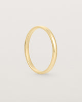 A fine, classic wedding band in yellow gold