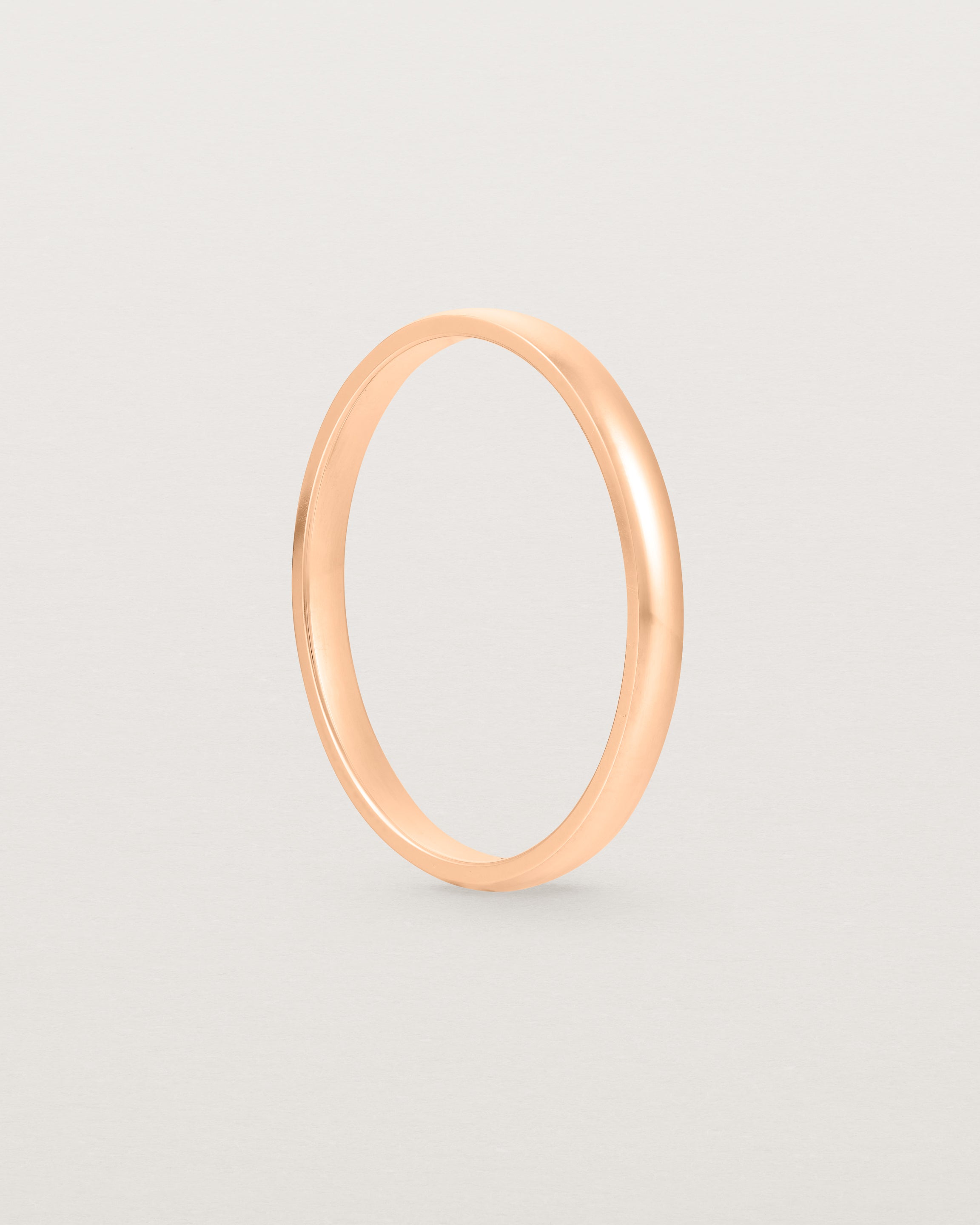 A fine classic wedding band in rose gold, side view