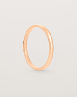 A fine classic wedding band in rose gold, side view