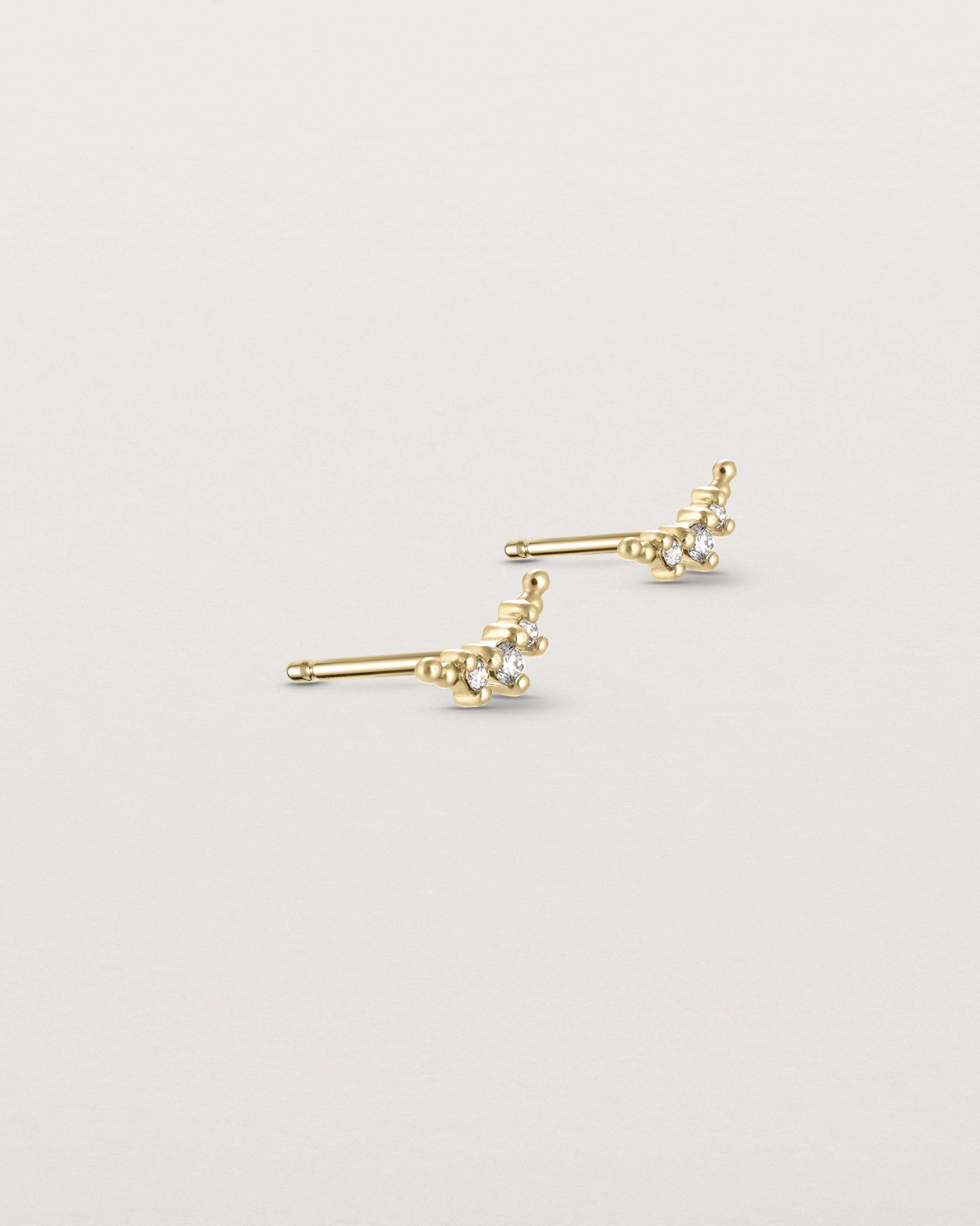 Angled view of the Crescent Studs | Diamonds in yellow gold.