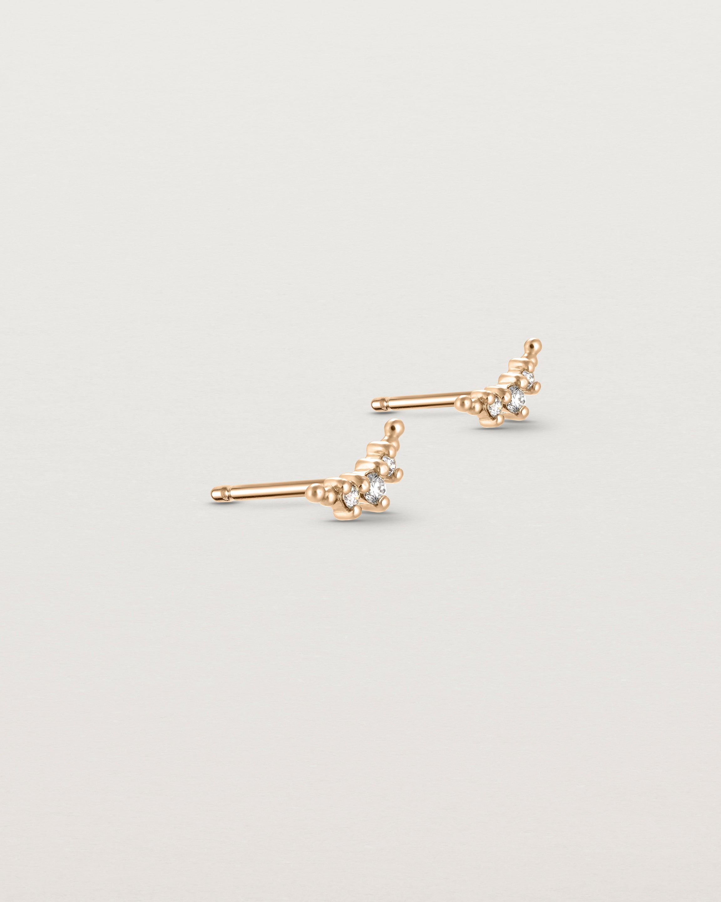 Angled view of the Crescent Studs | Diamonds in rose gold.
