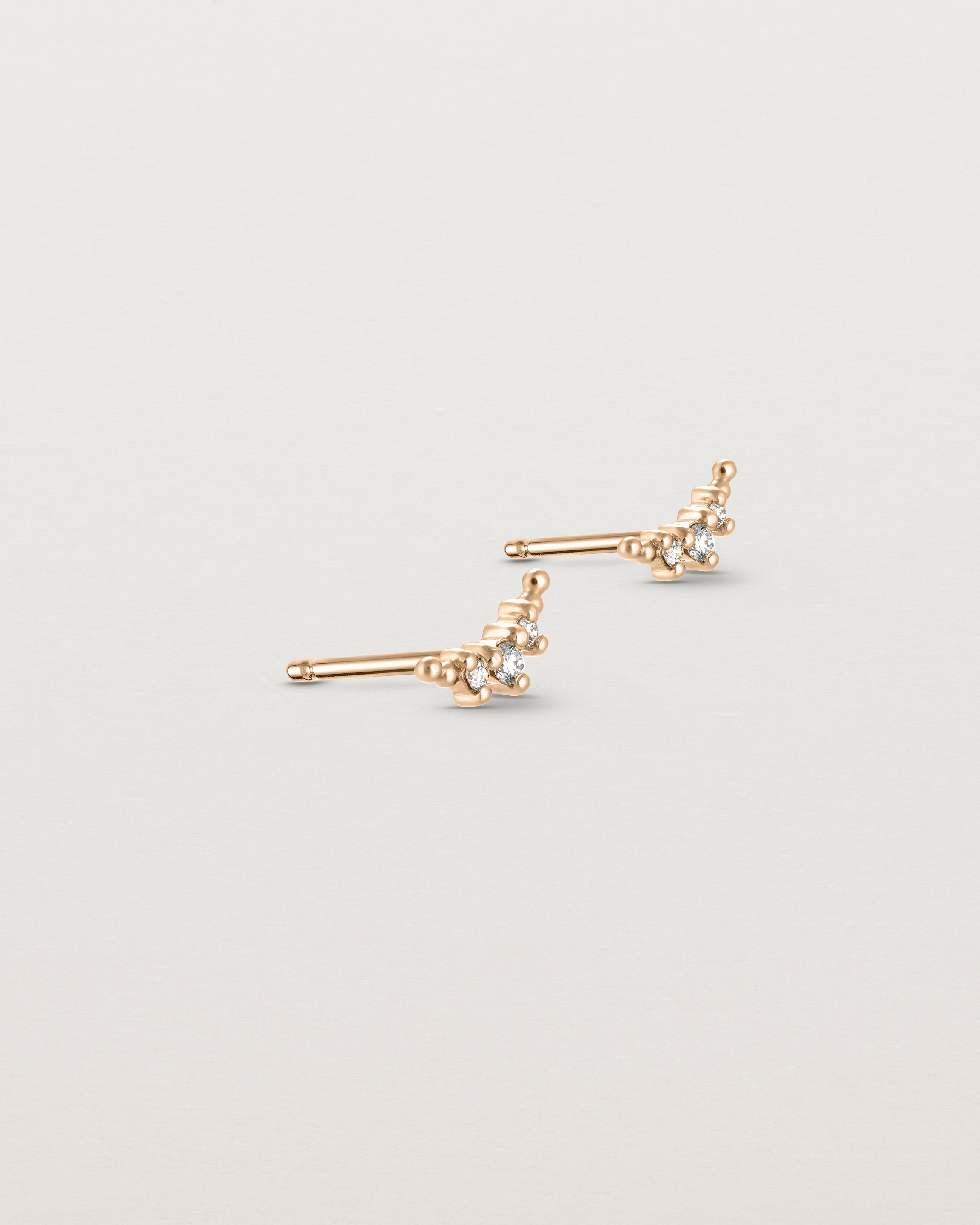 Angled view of the Crescent Studs | Diamonds in rose gold.