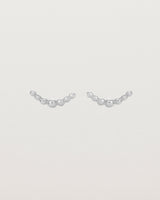 A pair of sterling silver studs featuring an arc of round metal balls