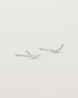 A pair of sterling silver studs featuring an arc of round metal balls