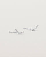 A pair of sterling silver studs featuring an arc of round metal balls