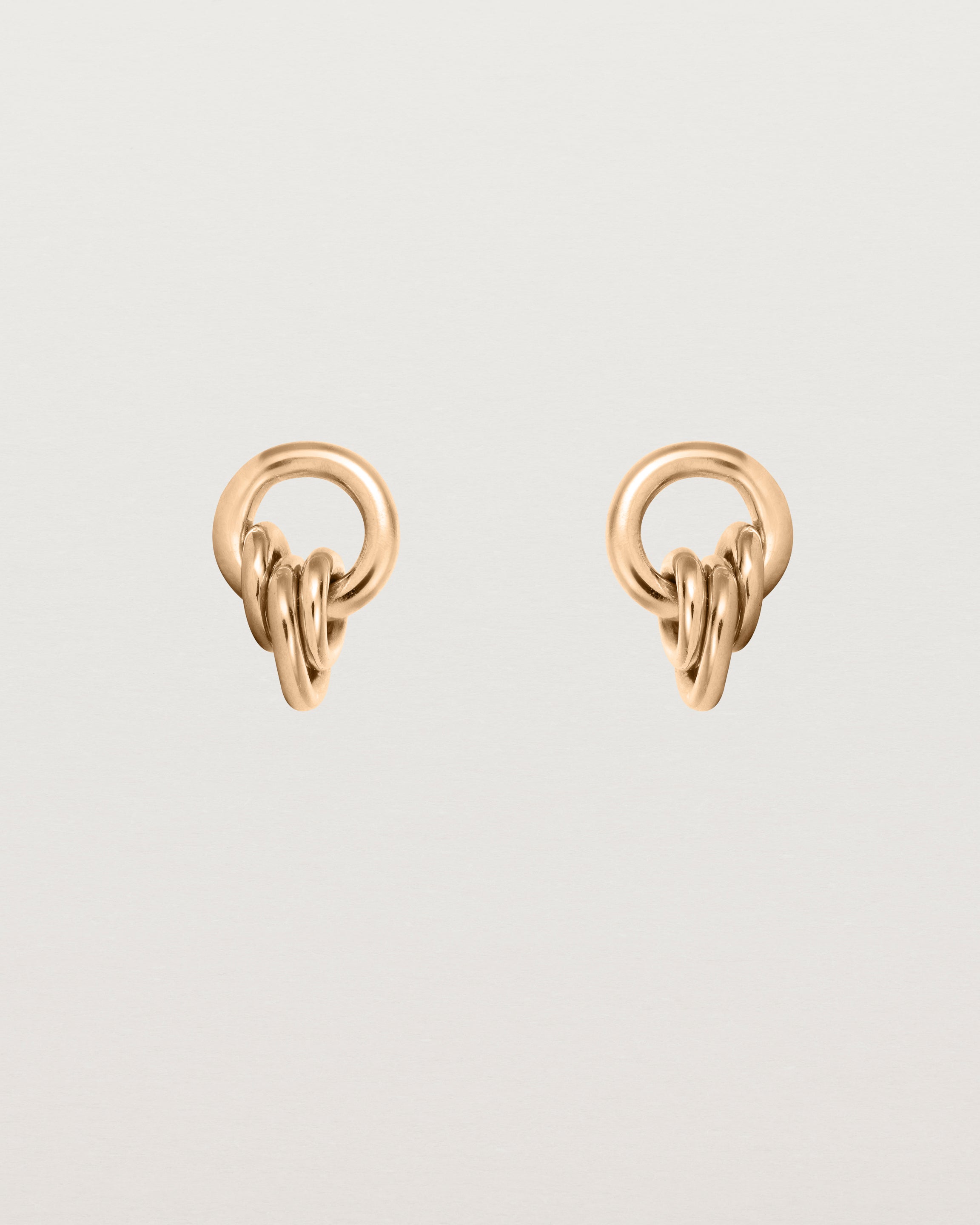 A pair of rose gold studs with three mini hoops attached