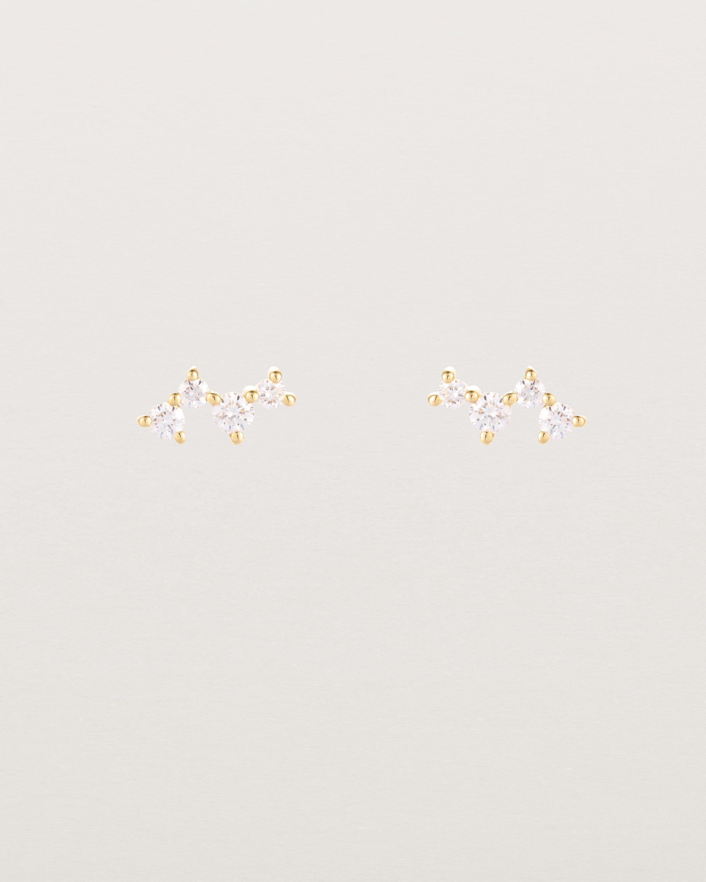 A pair of yellow gold studs featuring a cluster of four diamonds