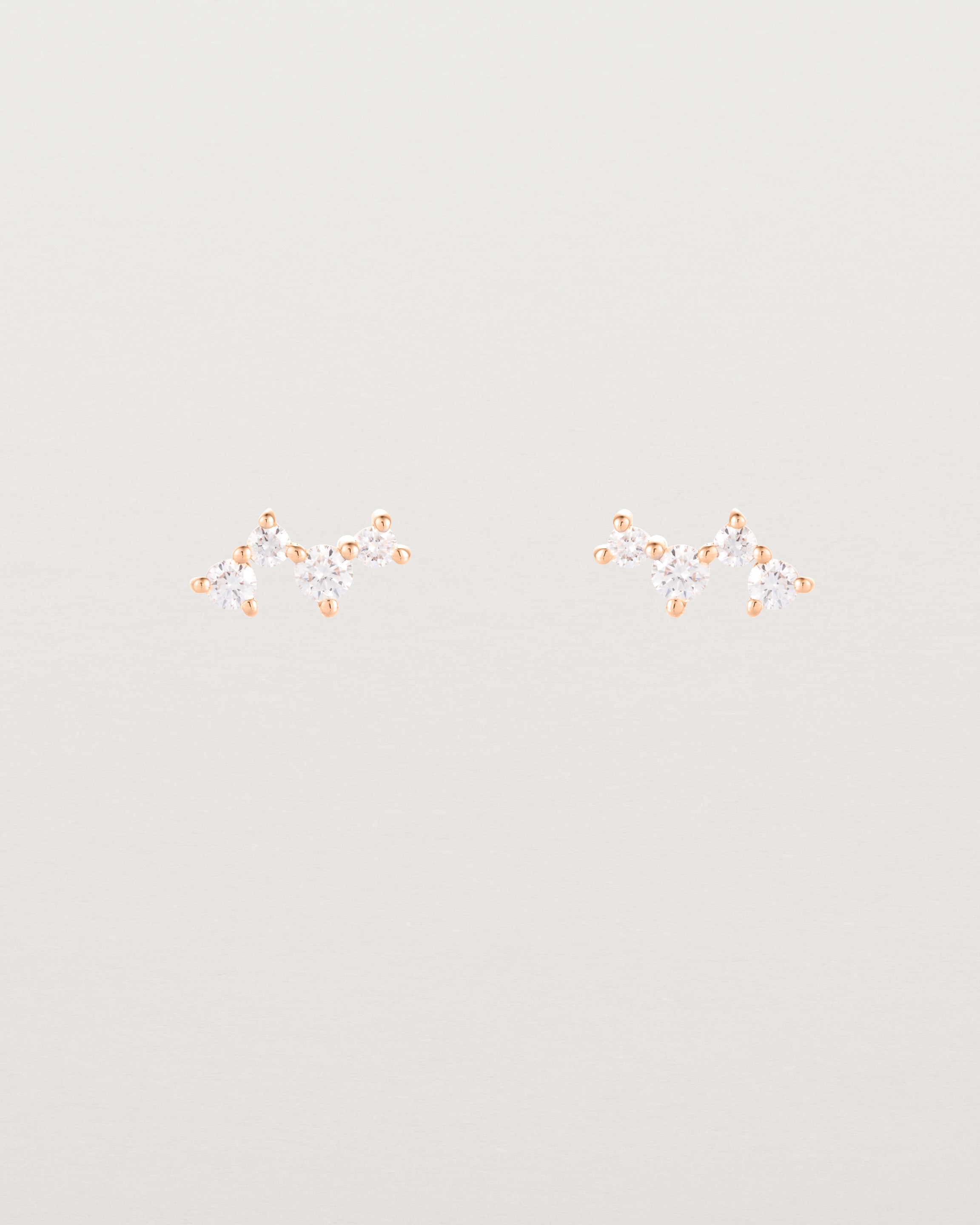 A pair of rose gold studs featuring a cluster of four diamonds