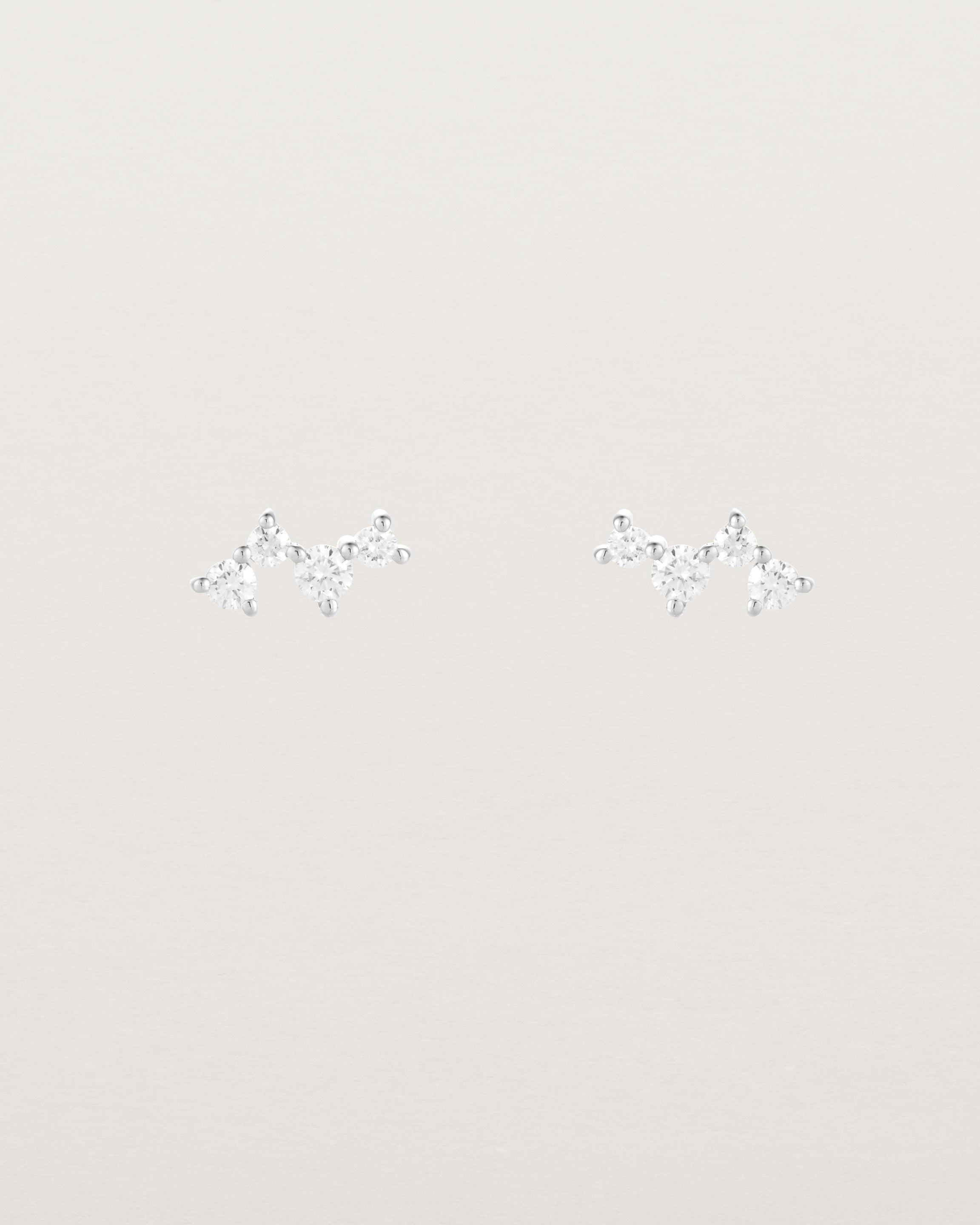 A pair of white gold studs featuring a cluster of four diamonds