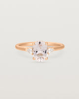 Oval morganite adorned with white diamonds on either side, featuring a sweeping setting and crafted in rose gold
