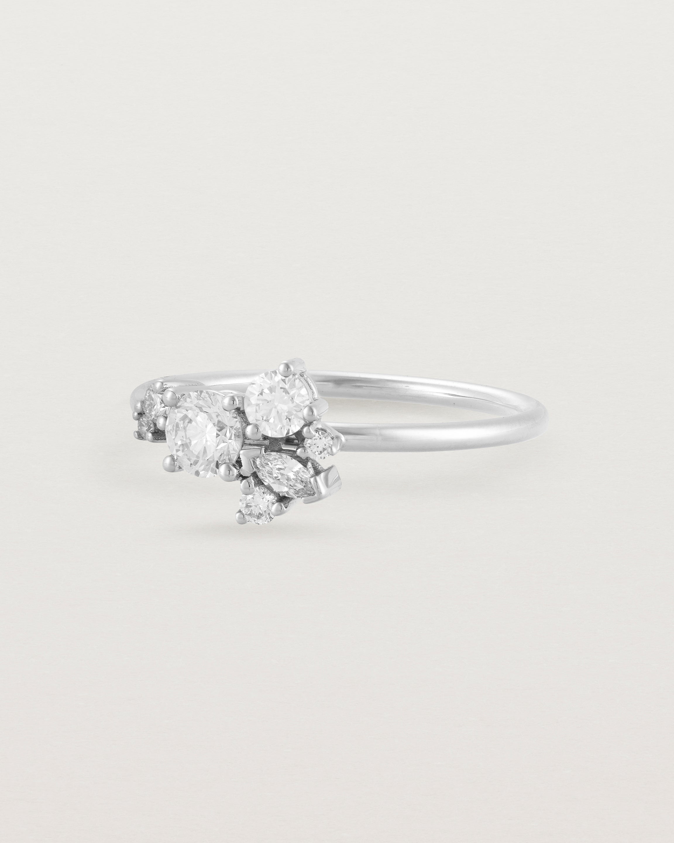 Side view of a white diamond cluster ring in white gold