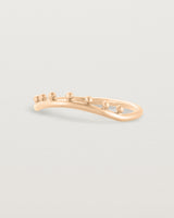Side view of a gentle arc ring featuring dot detailing along the top of the arc, crafted in rose gold.