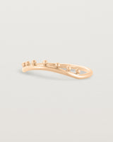 Side view of a gentle arc ring featuring dot detailing along the top of the arc, crafted in rose gold.