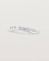 The side view of a gentle arc ring featuring dot detailing along the top of the arc, crafted in white gold.