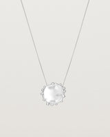A molten textured silver disc with dots around the circumstance on a silver fine chain necklace