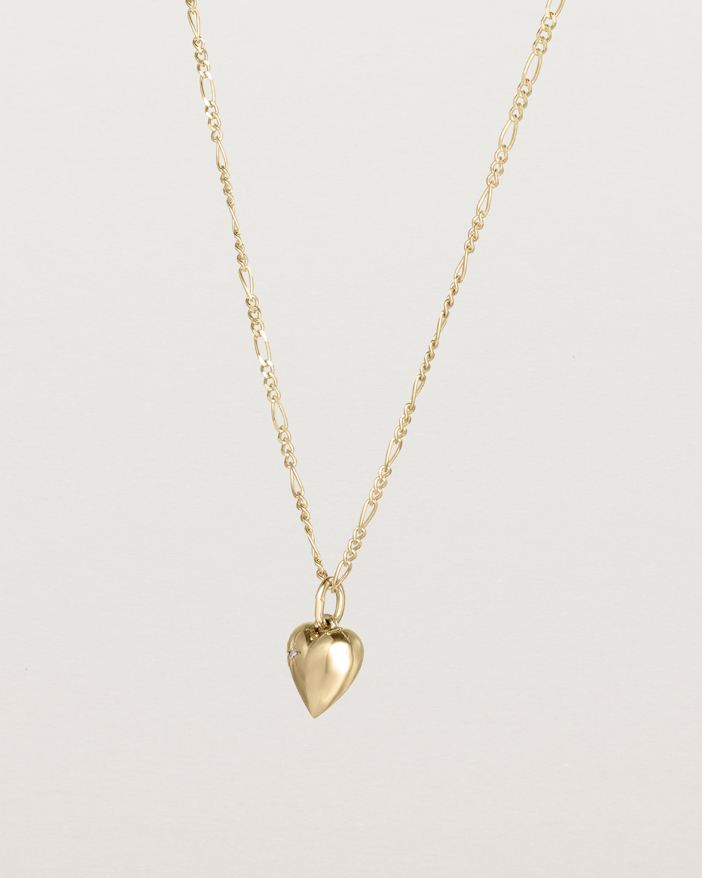 Angled view of the Ella Necklace with a star set diamond birthstone in yellow gold.