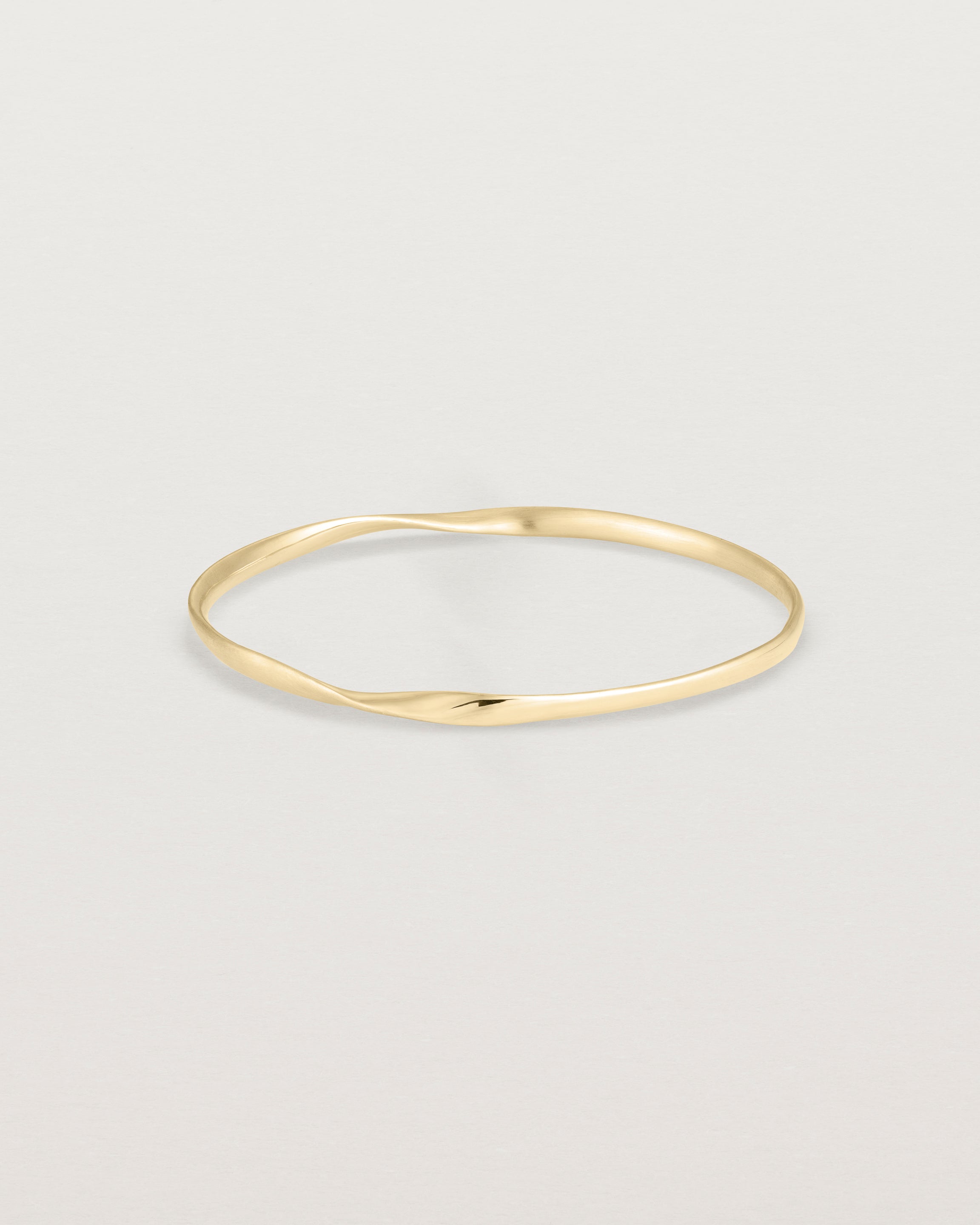 side view of the ellipse bangle in yellow gold