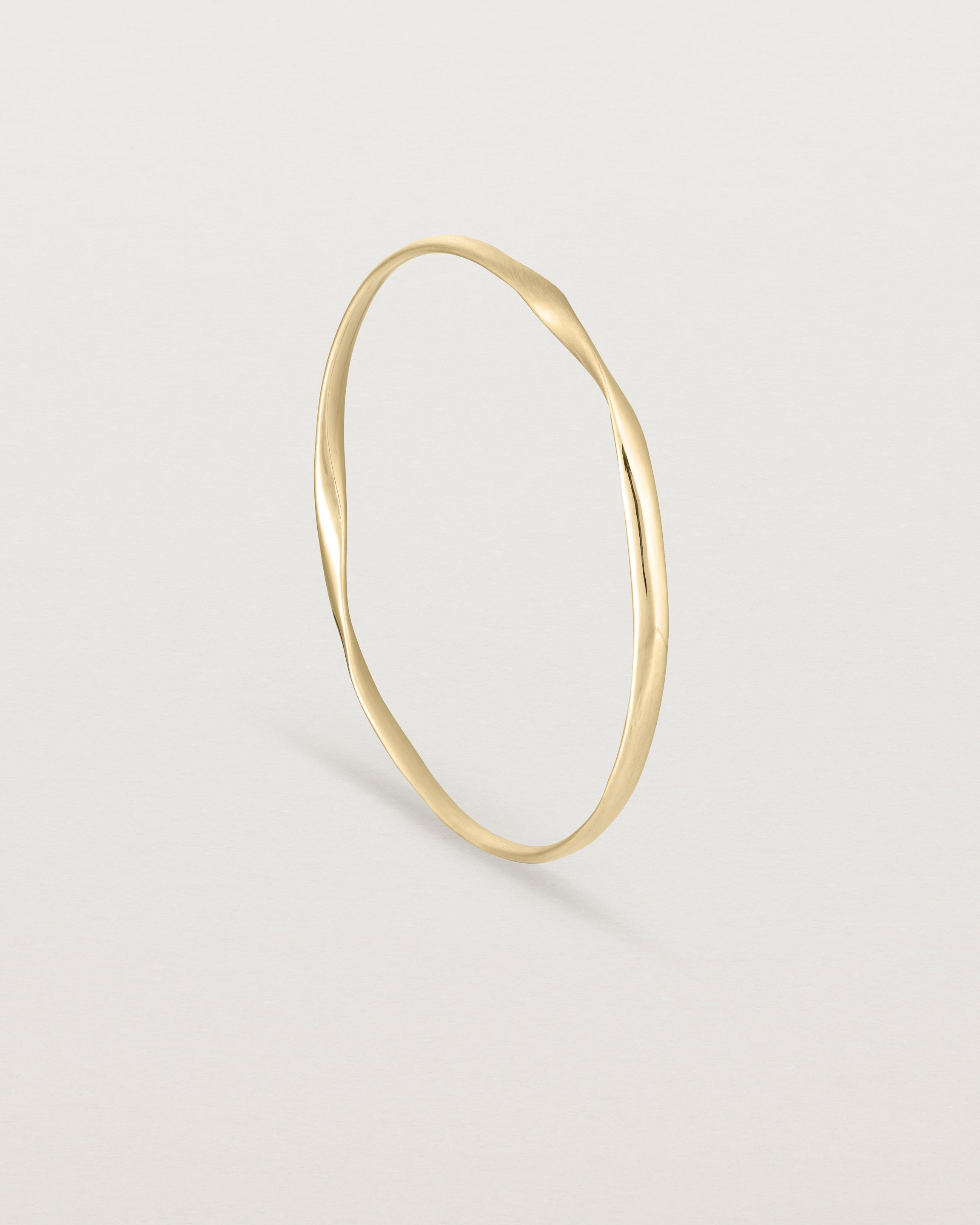 standing view of the ellipse bangle in yellow gold