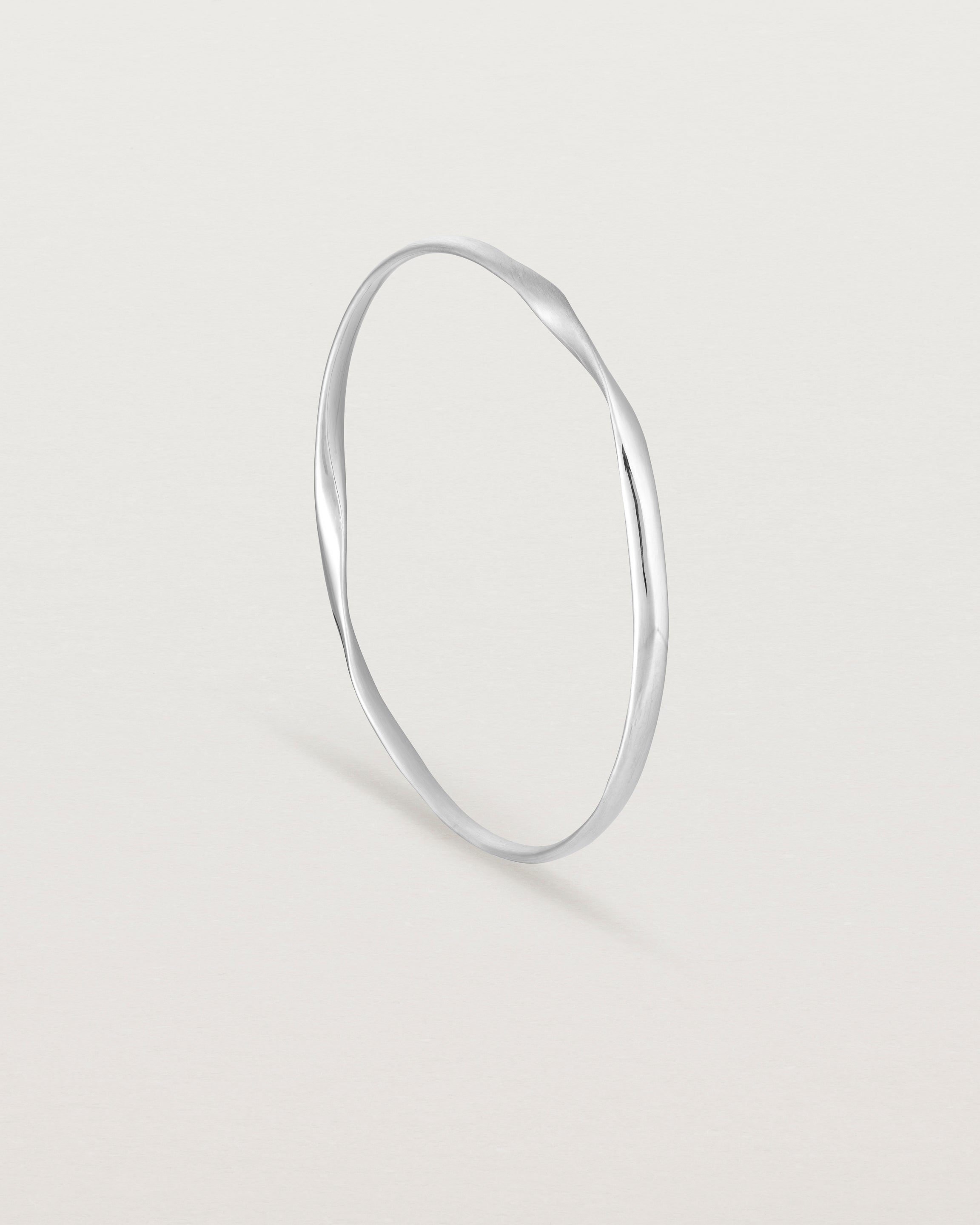 standing angle view of the ellipse bangle in sterling silver