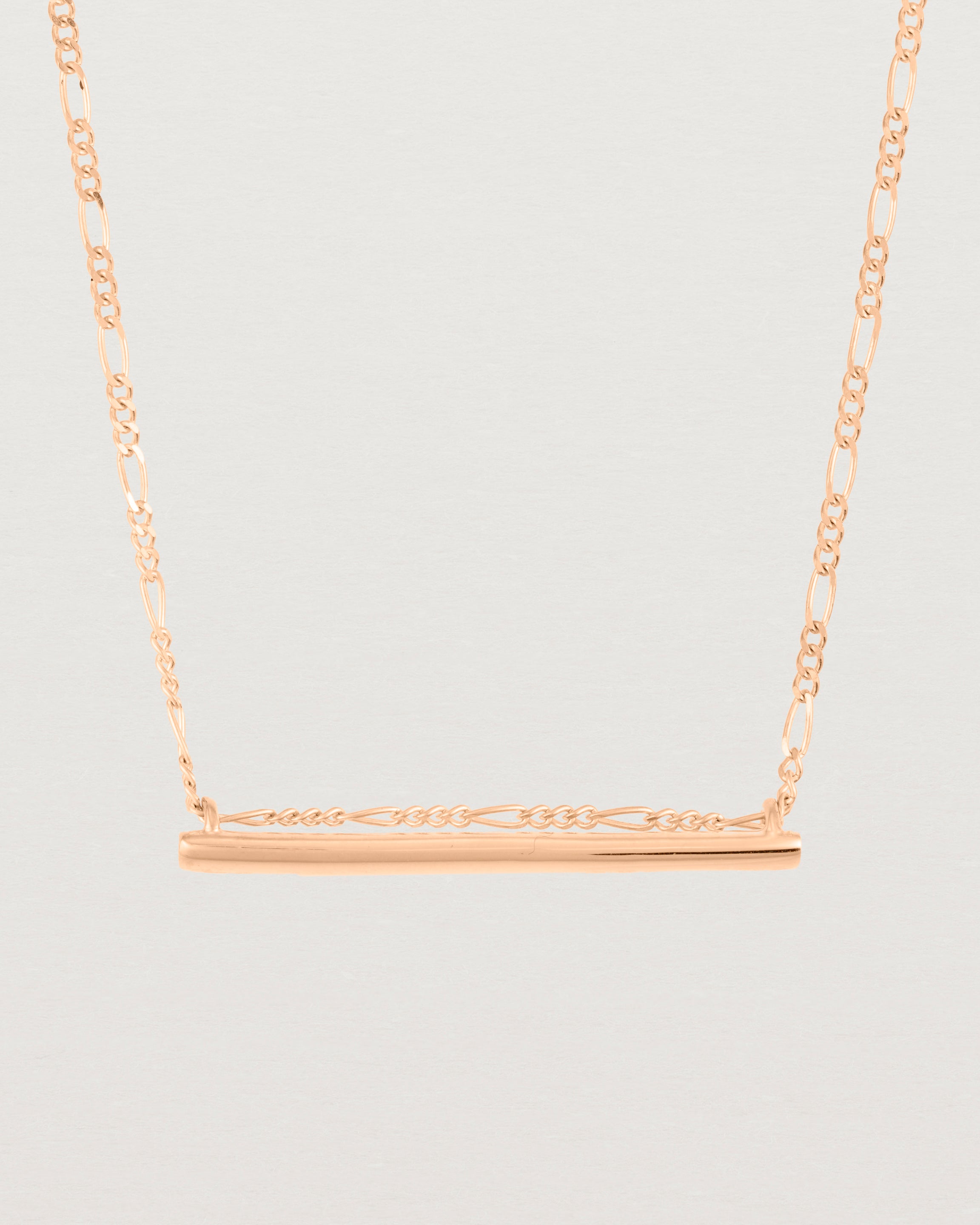 close up of Ellipse necklace with a rose gold bar hanging from a chain in rose gold