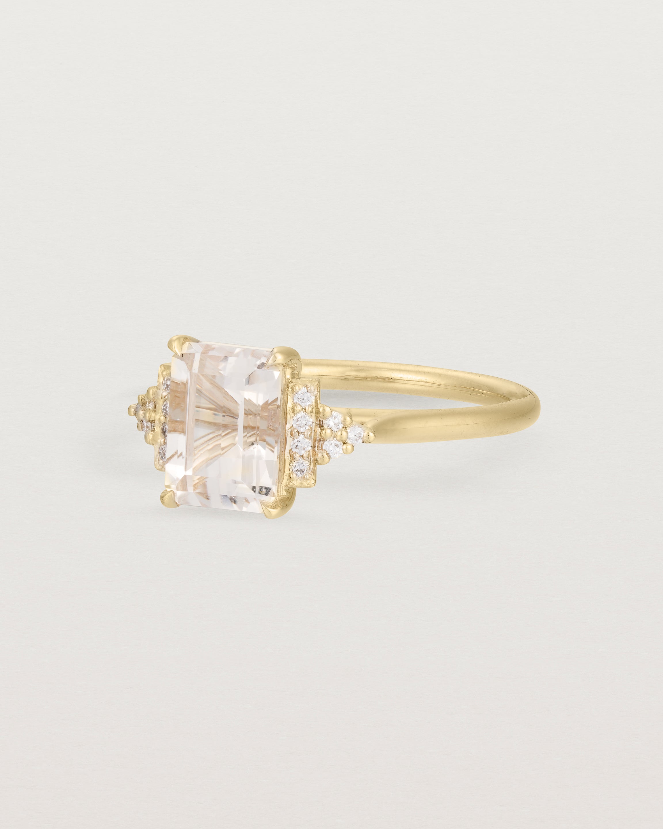 Side view of the Elodie Ring featuring a pale pink emerald cut morganite in yellow gold