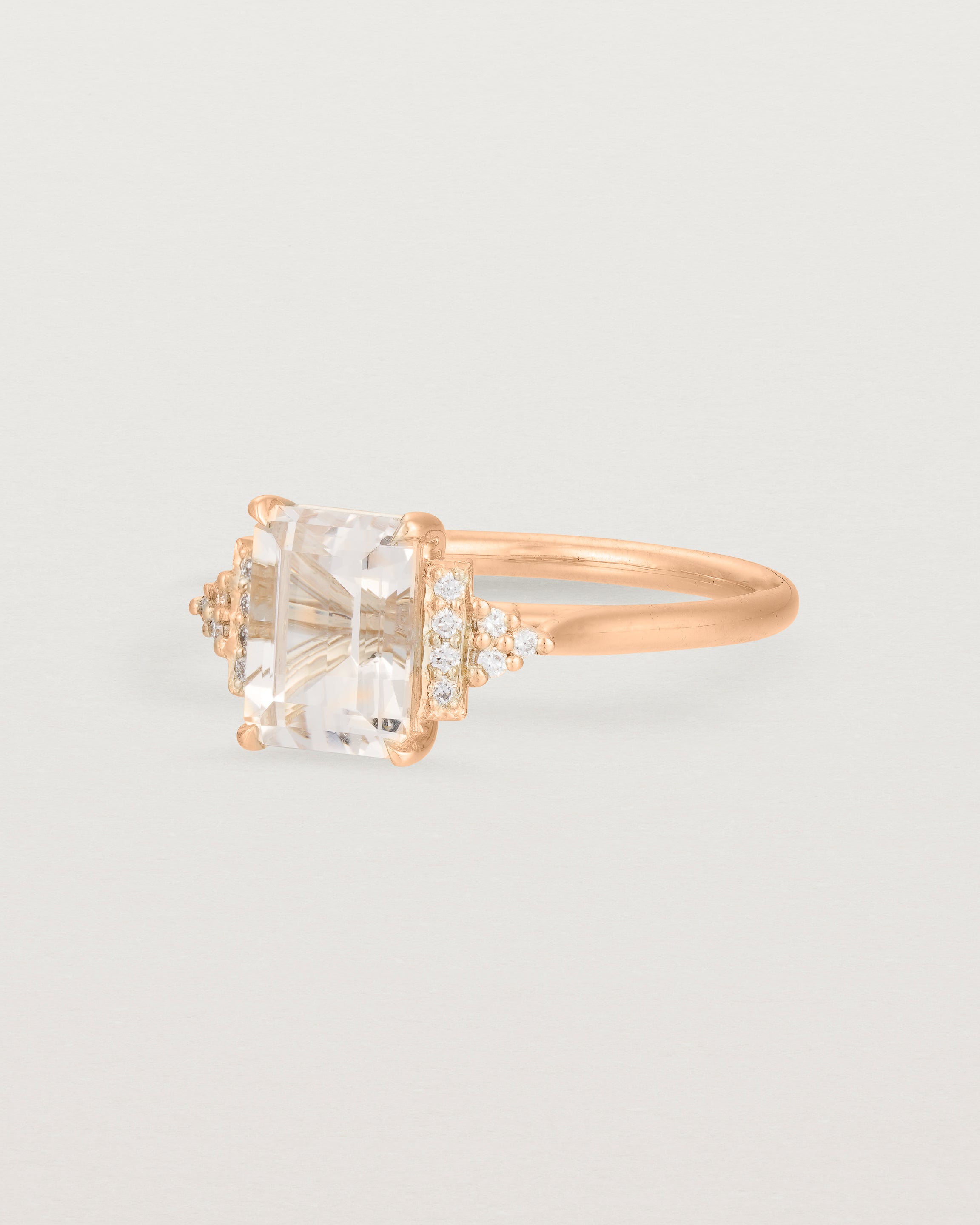 Side view of the Elodie Ring featuring a pale pink emerald cut morganite in rose gold