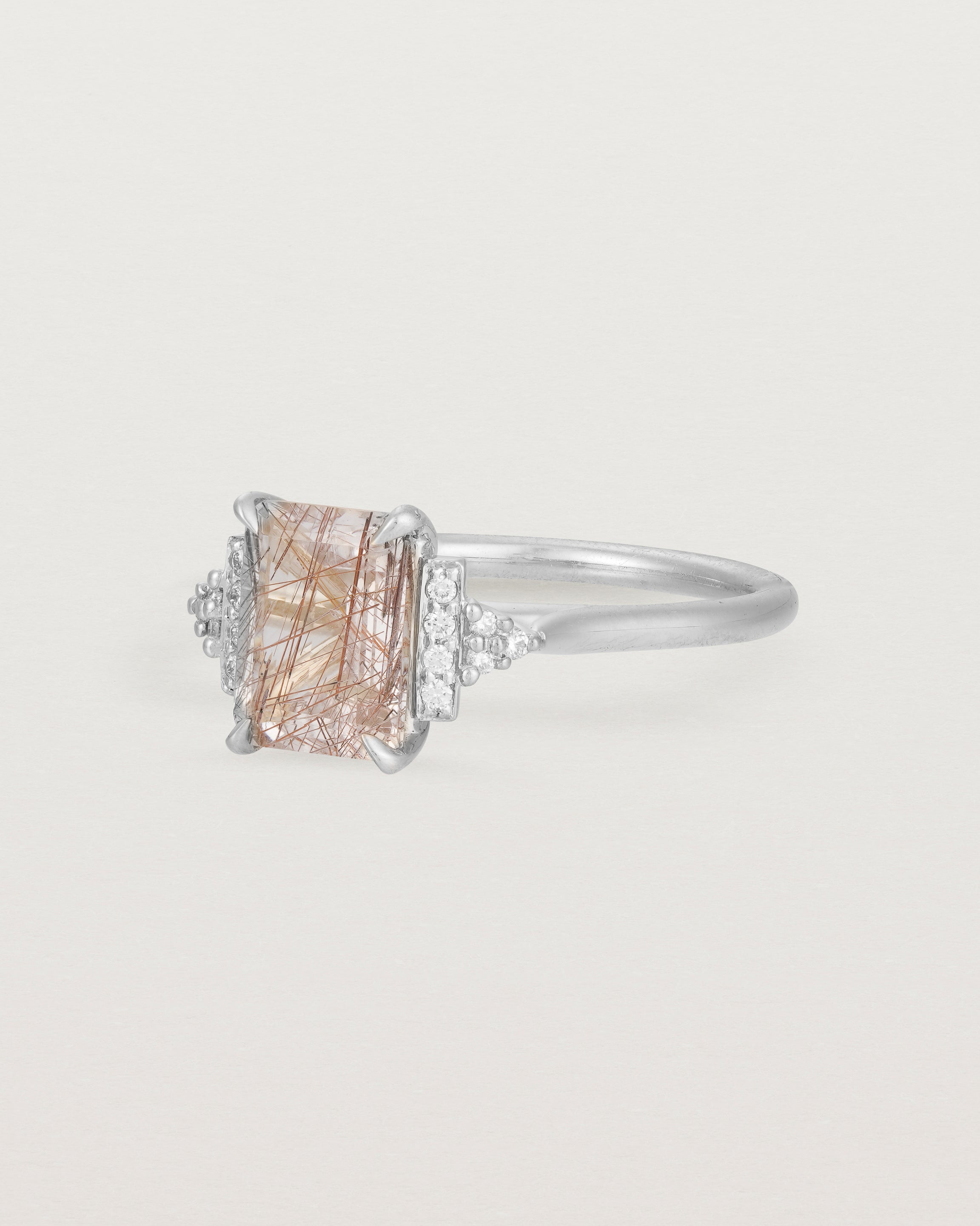 Side view of the Elodie Ring featuring a emerald cut rutilated quartz in white gold