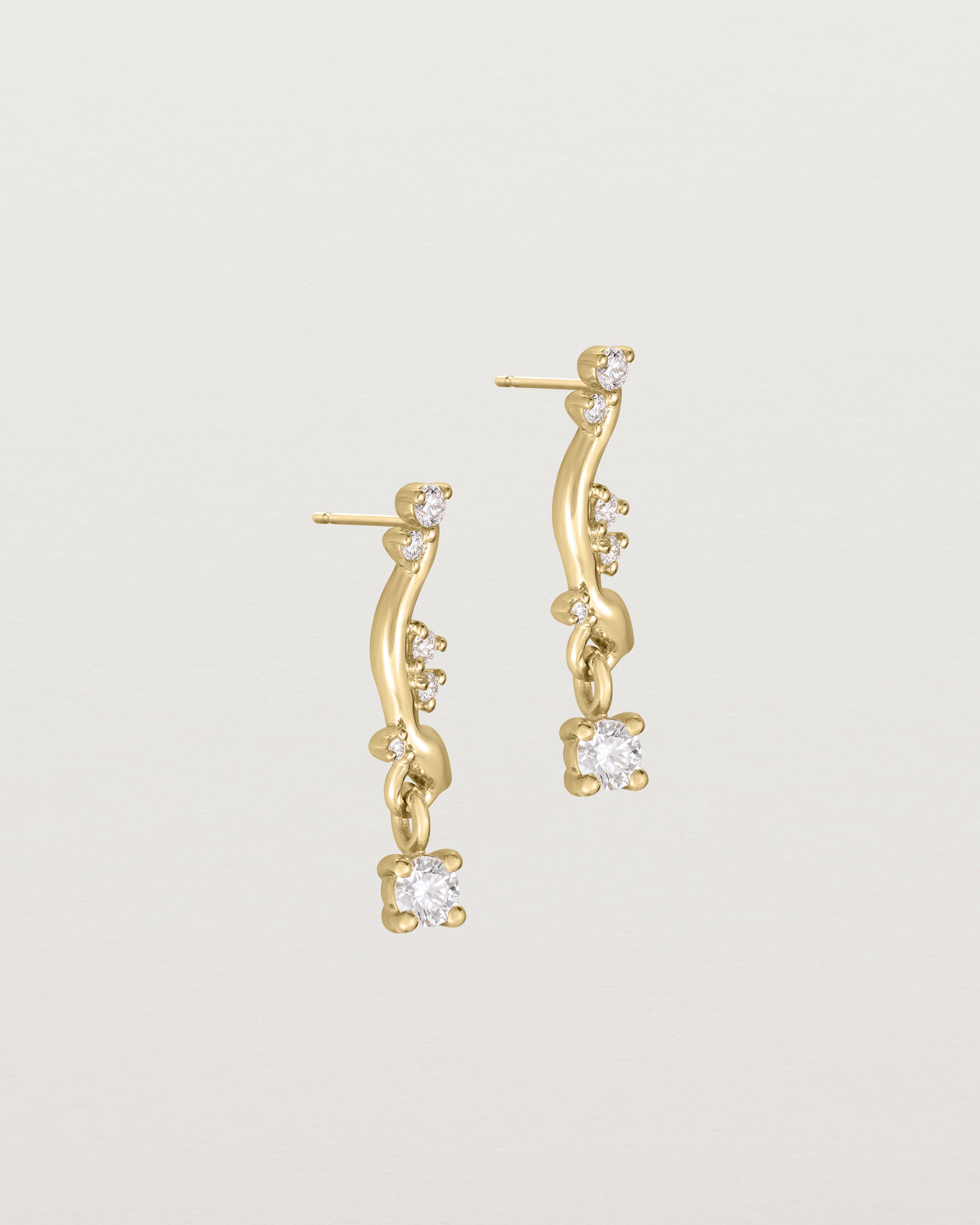 side image of diamond drop ember earrings in yellow gold.