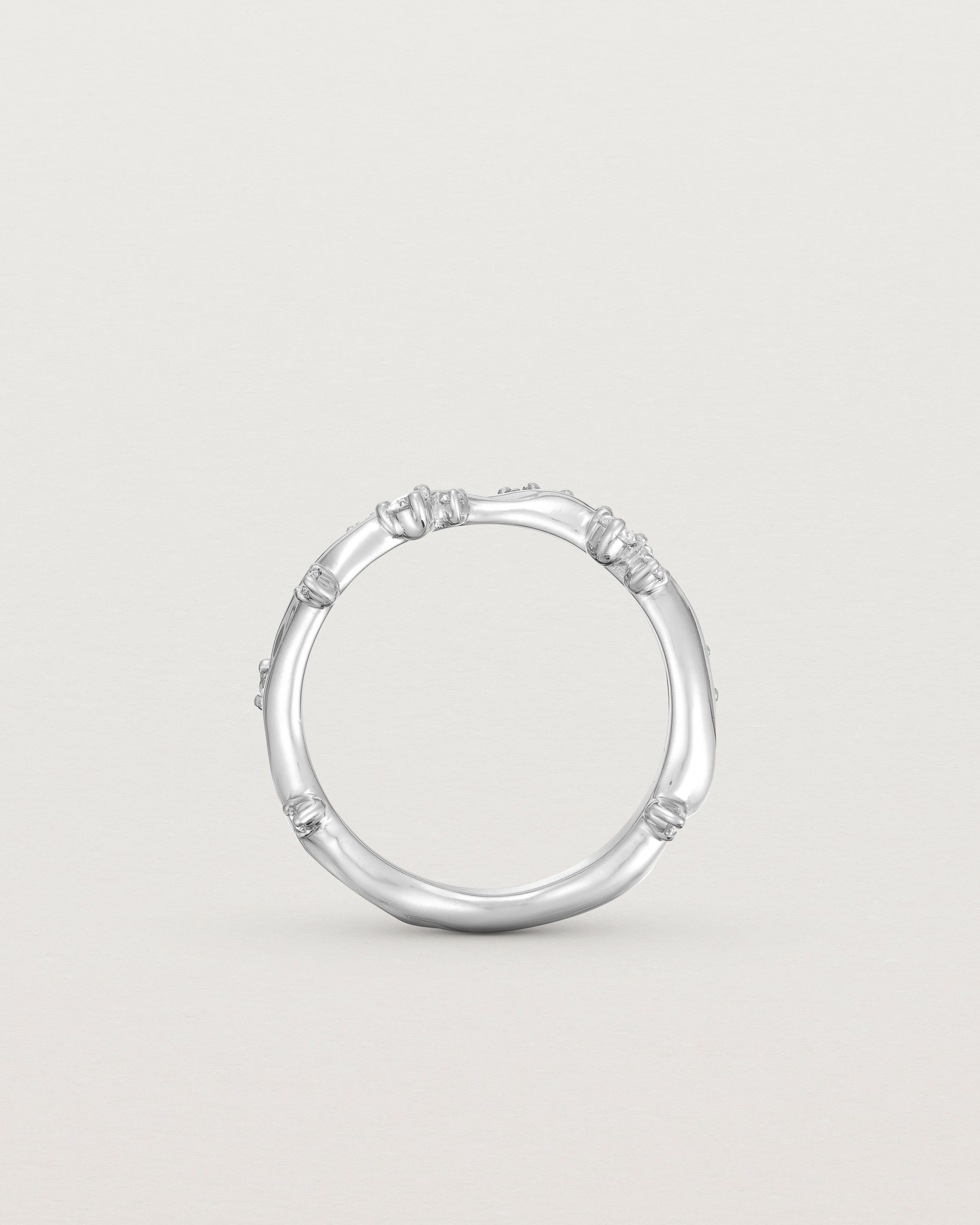 Standing image - Product photo of the white gold Ember ring with white diamonds scattered around the band.