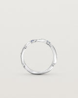 Standing image of the Ember ring in white gold featuring a scattering of white diamonds and blue sapphires.