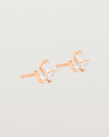 A pair of rose gold studs featuring three pear shaped diamonds