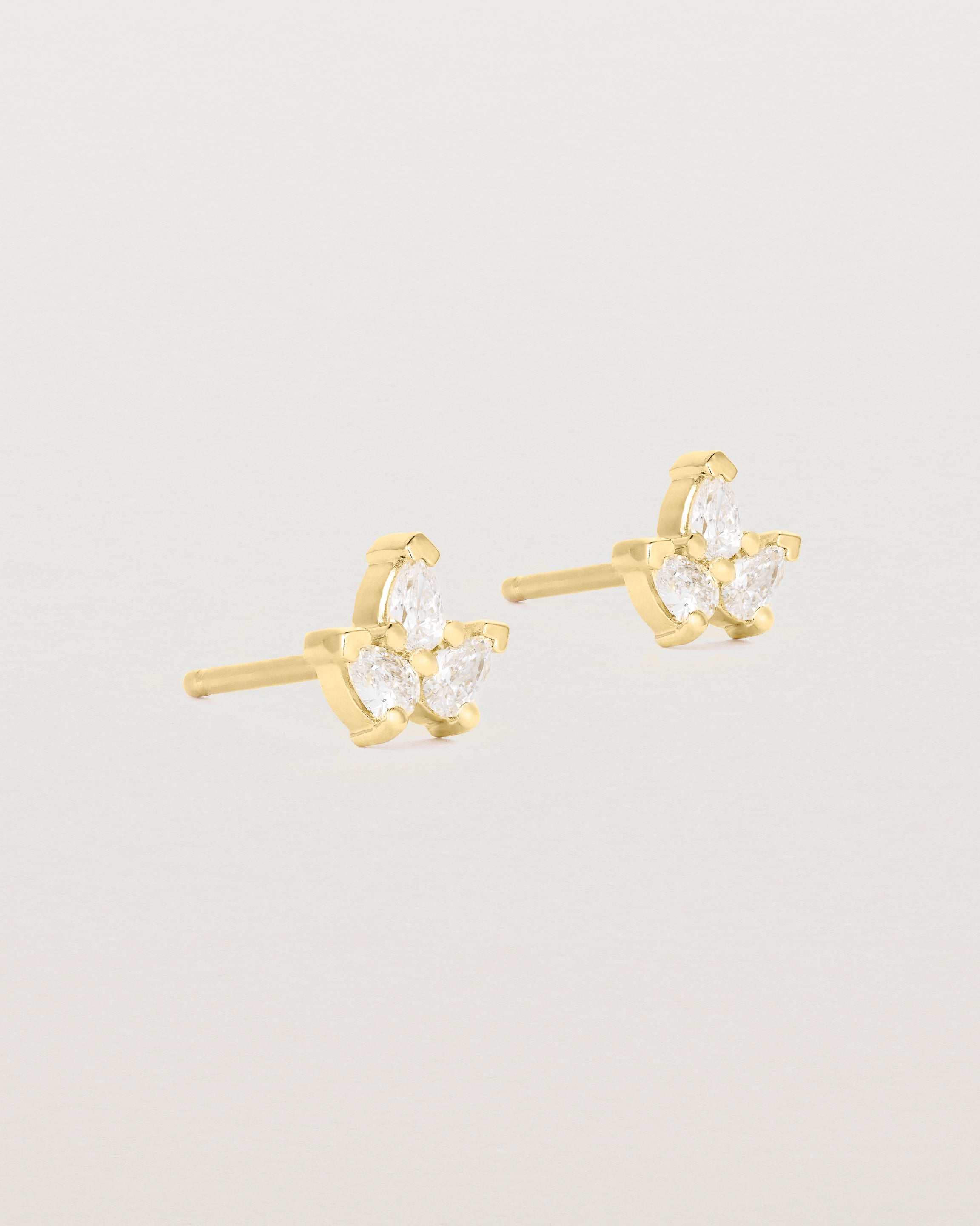 A pair of yellow gold studs featuring three pear shaped diamonds