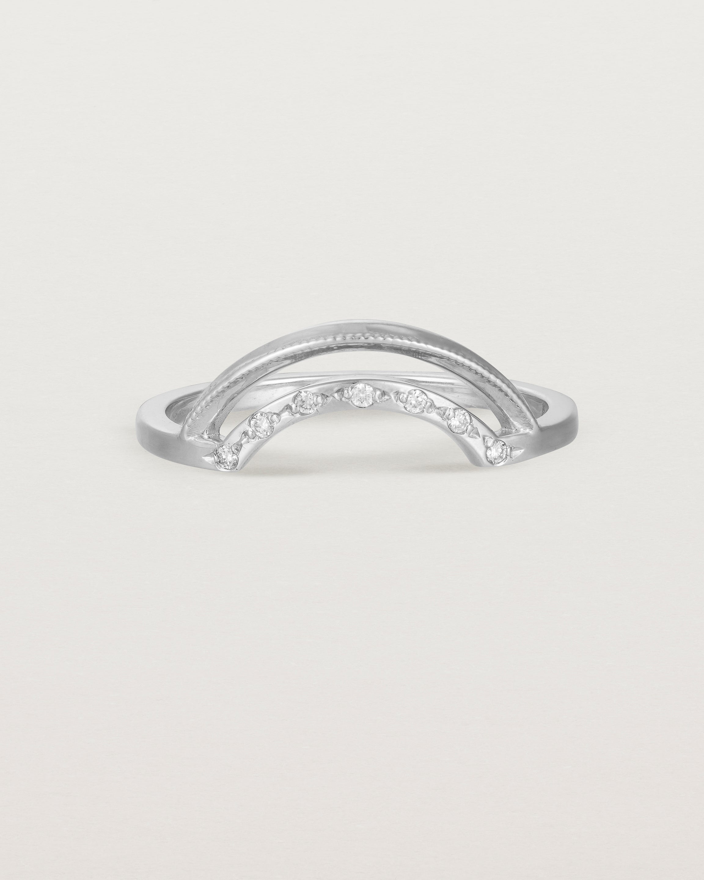 Fit three of a double arc crown ring with white diamonds adoring the inner arc - crafted in white gold.
