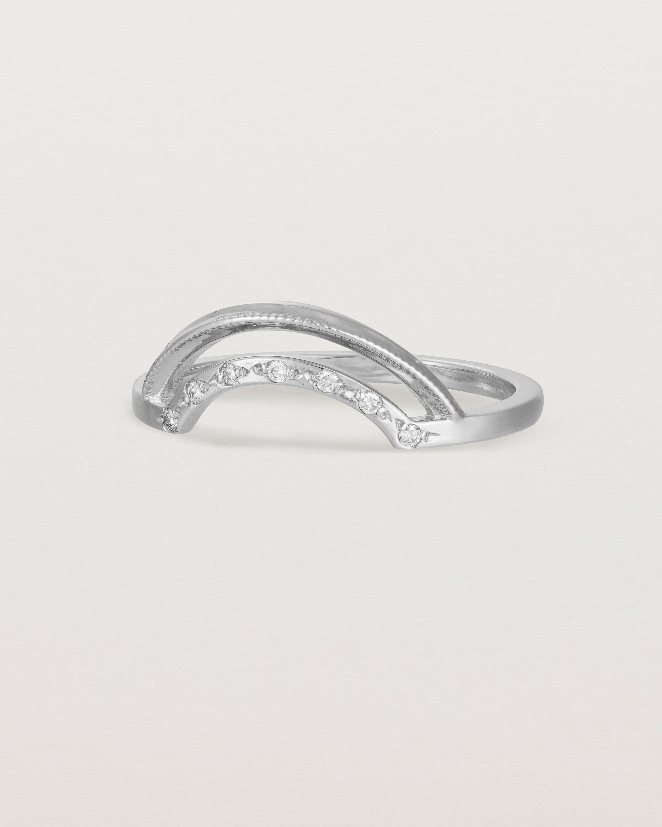 Fit three of a double arc crown ring with white diamonds adoring the inner arc - crafted in white gold.
