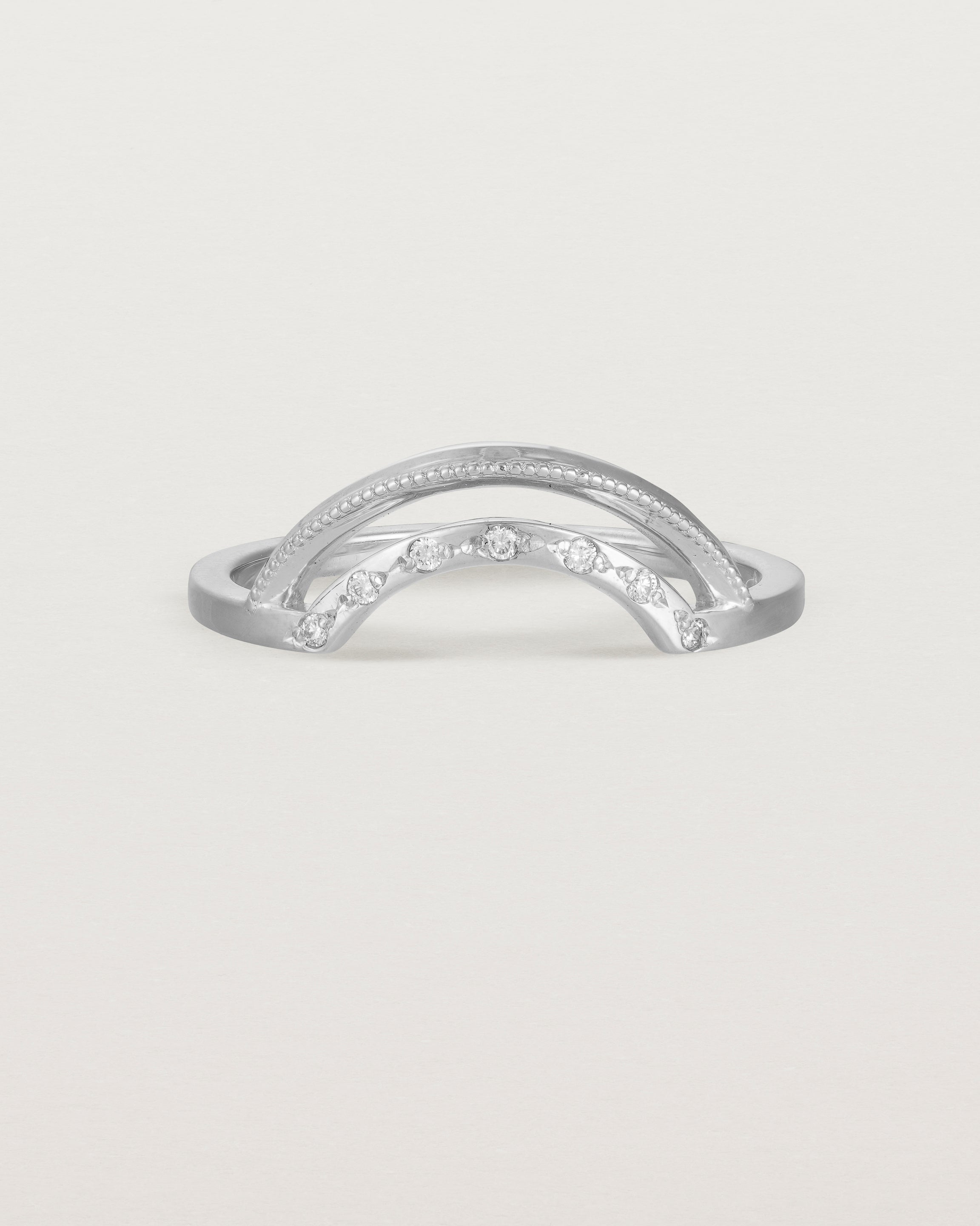 Fit four of a double arc crown ring with white diamonds adoring the inner arc - crafted in white gold.