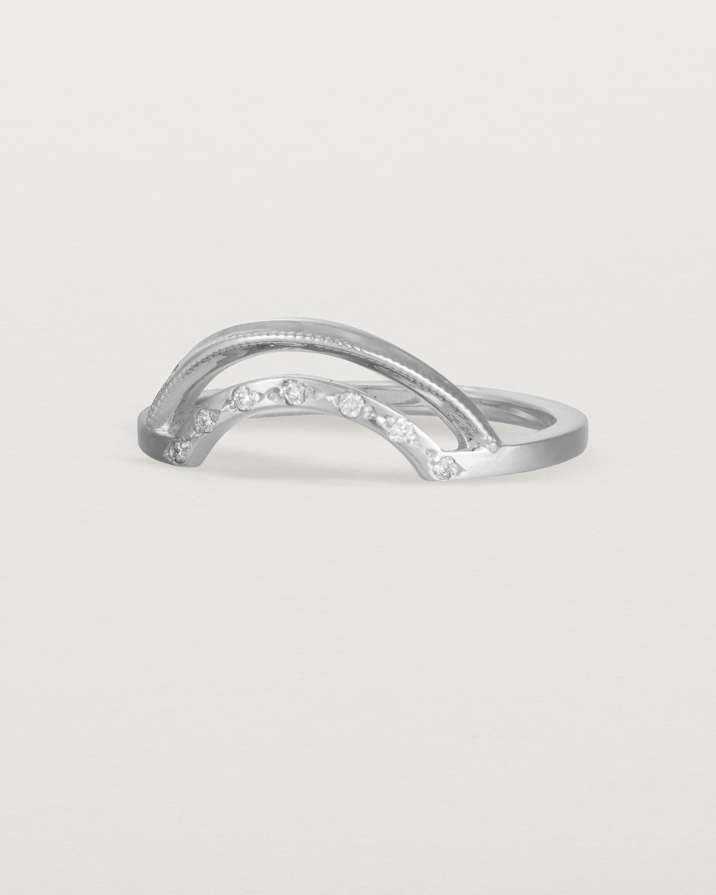 Fit four of a double arc crown ring with white diamonds adoring the inner arc - crafted in white gold.